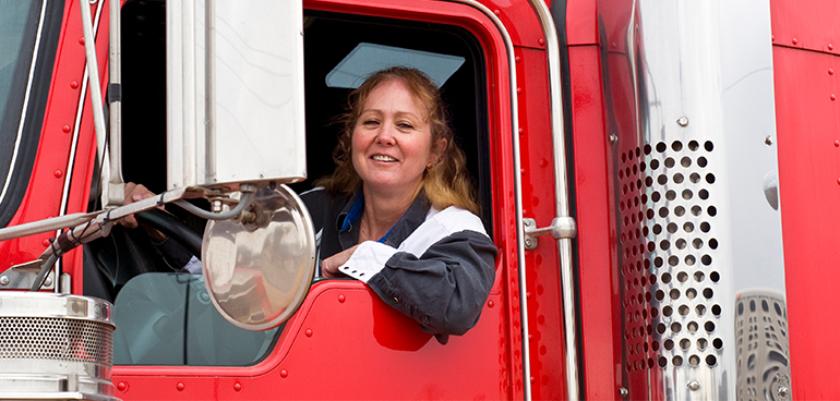 Kvinnlig lastbilschaufför sitter i en röd lastbil