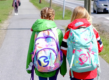 Barn med ryggsäck påväg till skolan