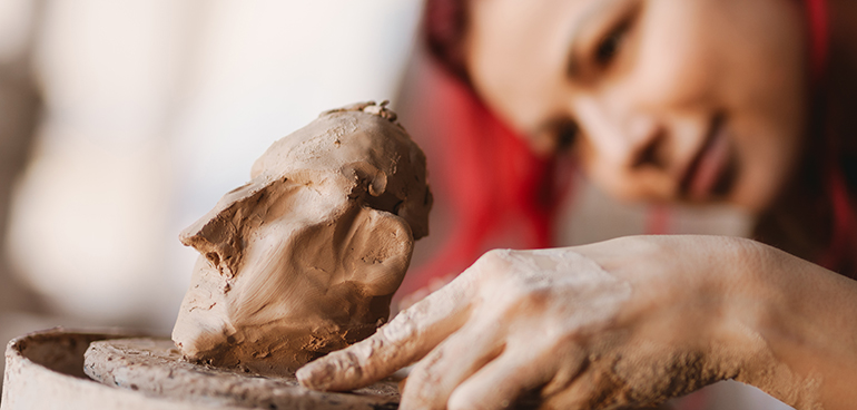 Konstnär skulpterar i lera